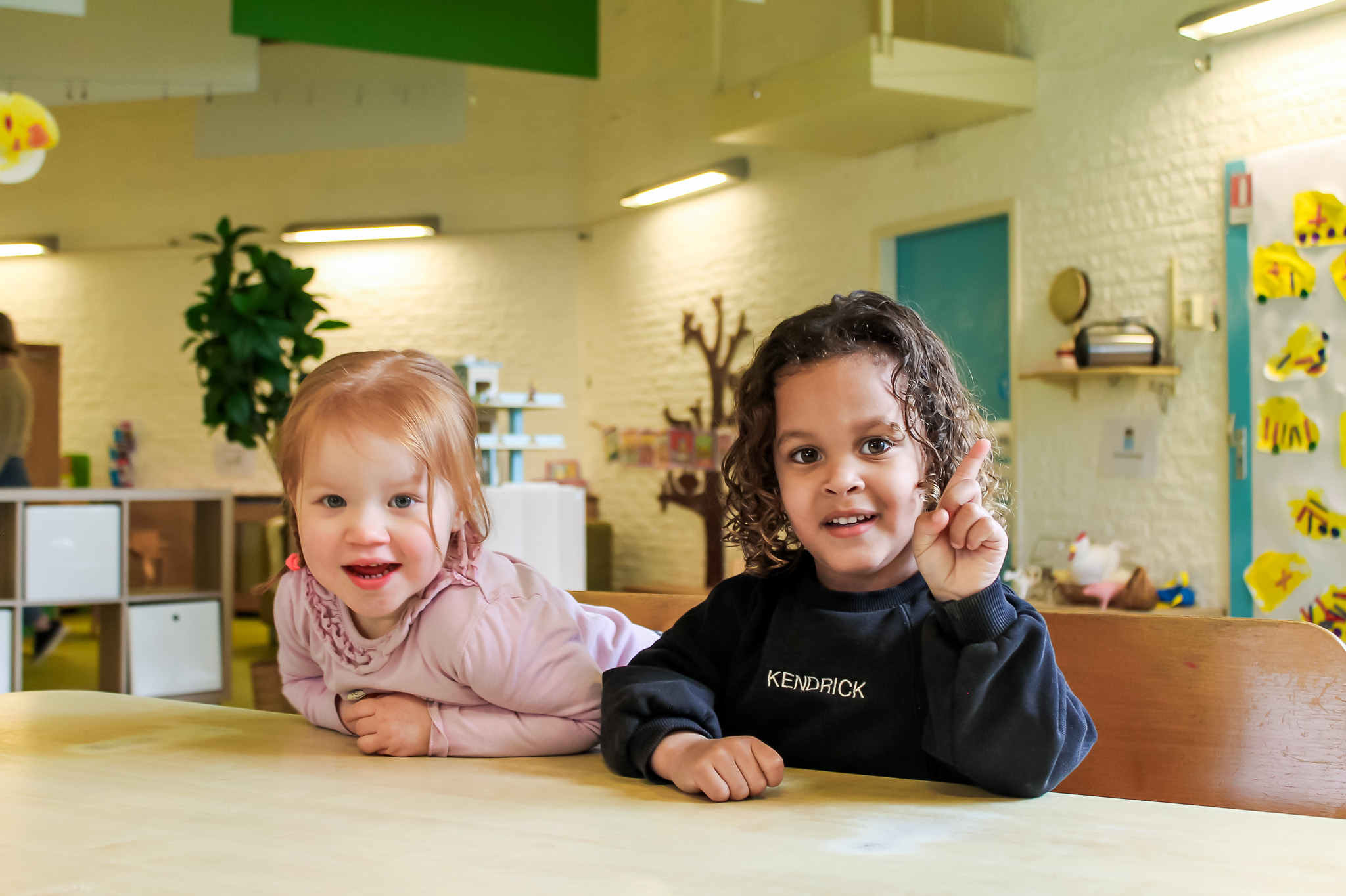 Twee kinderen zitten aan tafel en hebben het leuk samen bij peuteropvang Het Mosterdzaadje in Purmerend